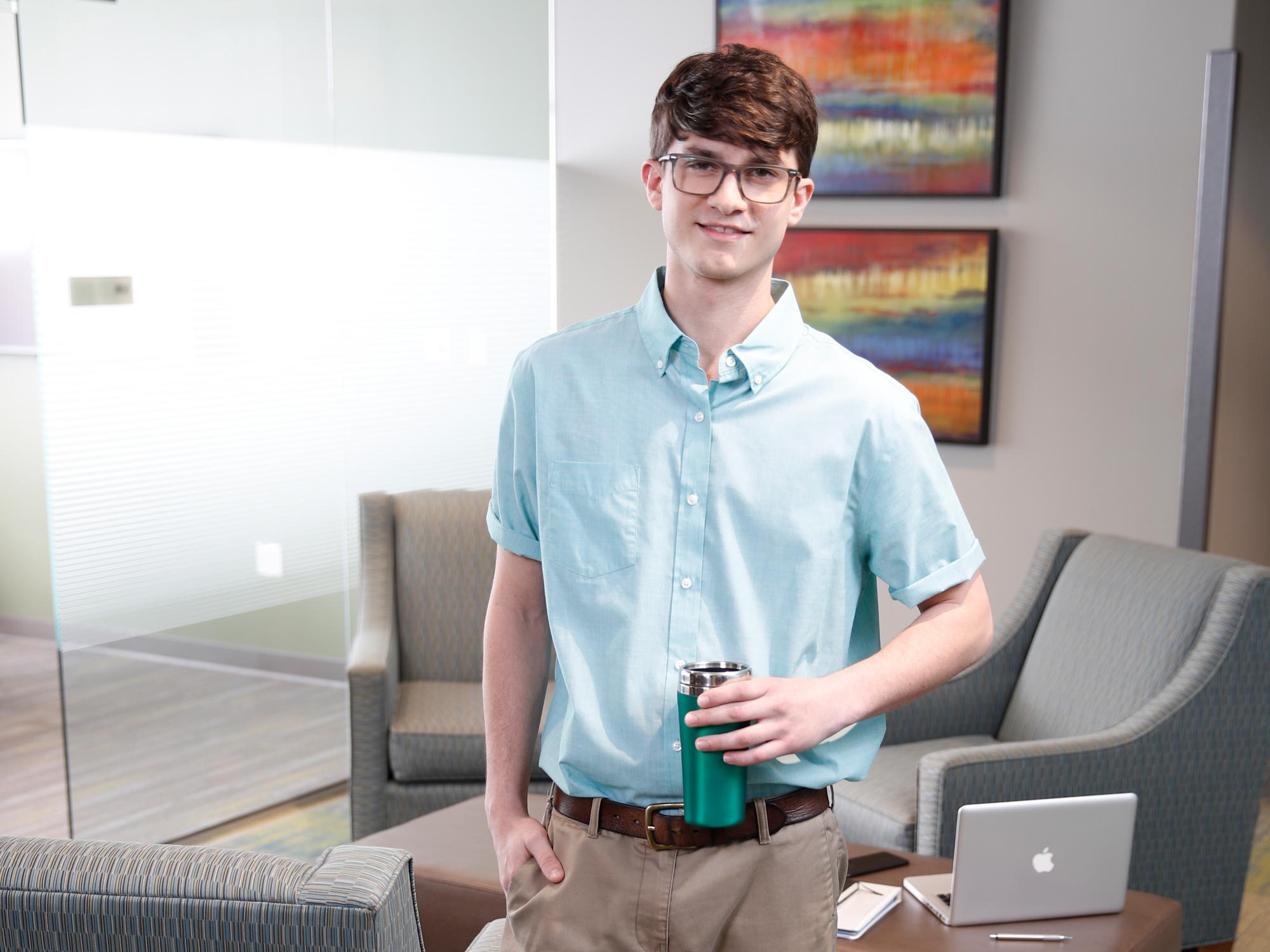 Male student with glasses and coffee mug